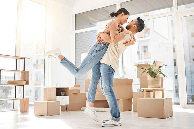 https://www.quicken.com/blog/wp-content/uploads/2022/12/smiling-couple-hugging-in-room-with-moving-boxes.jpg