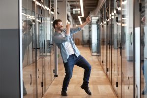 Man dancing in an office hallway