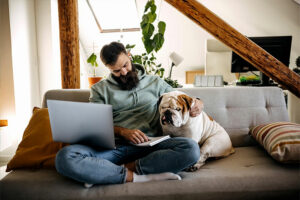 Man using laptop while petting dog