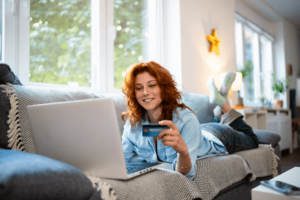 Young redhead Caucasian woman using credit card.