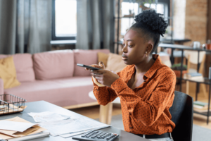 Young African female auditor taking photo of financial papers