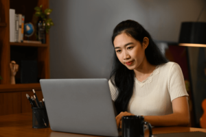 Concentrated young woman watching online lecture during studying online on laptop.