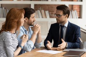 Interested young family couple visiting financial advisor in office.