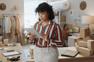 Startup, boxes and woman with a tablet, business and app with connection, internet and digital app.